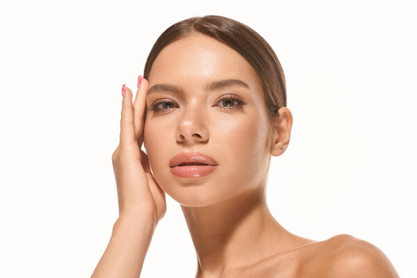 A young woman displays her natural beauty and confidence against a simple white background.