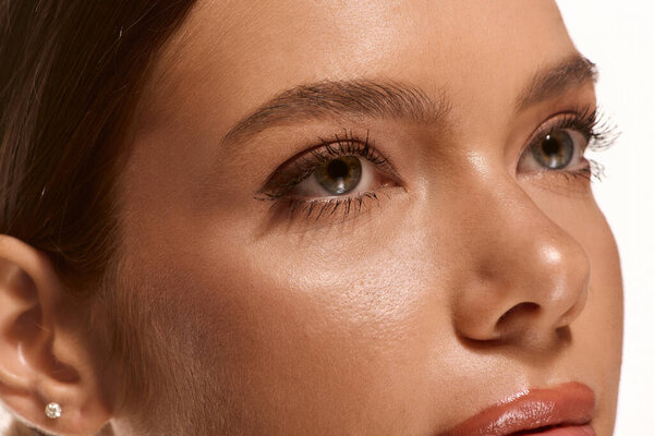 A young woman showcases her natural makeup look, exuding confidence and grace.