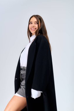 Beautiful young woman poses confidently in a stylish autumn outfit, embracing the seasonal vibe.