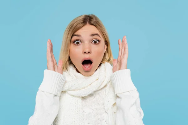 Shocked young woman with opened mouth gesturing and looking at camera isolated on blue — Stock Photo