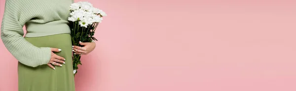 Cropped view of pregnant woman holding bouquet of white flowers isolated on pink, banner — Stock Photo
