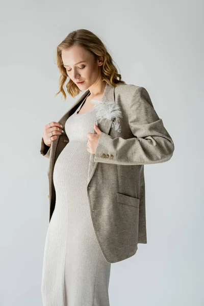 Mujer embarazada de moda en vestido con chaqueta aislada en gris - foto de stock