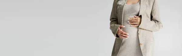 Vista parziale della donna incinta in abito beige toccante pancia isolata su grigio, banner — Foto stock