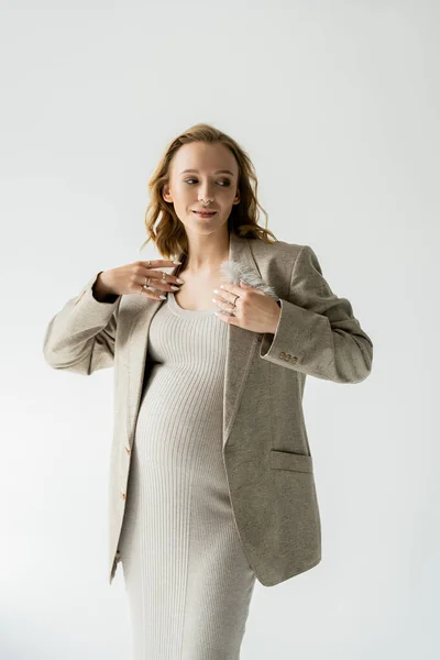 Mulher grávida elegante em vestido e casaco olhando para longe isolado em cinza — Fotografia de Stock