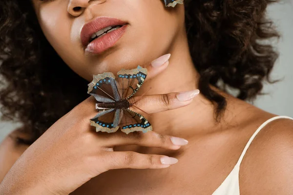 Abgeschnittene Ansicht einer afrikanisch-amerikanischen Frau mit Schmetterling auf der Hand isoliert auf grau — Stockfoto