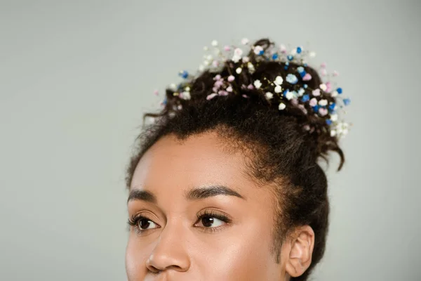 Обрезанный вид на молодую африканскую американку с цветущими цветами гипсофилы в волосах, изолированных на сером — стоковое фото