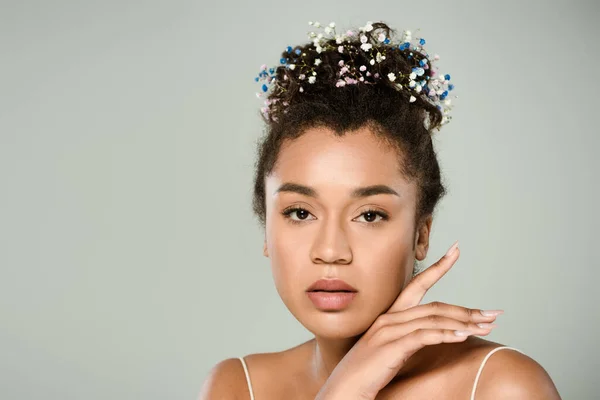 Молода афроамериканка з квітами гіпсофіли в волоссі ізольована на сірому — стокове фото