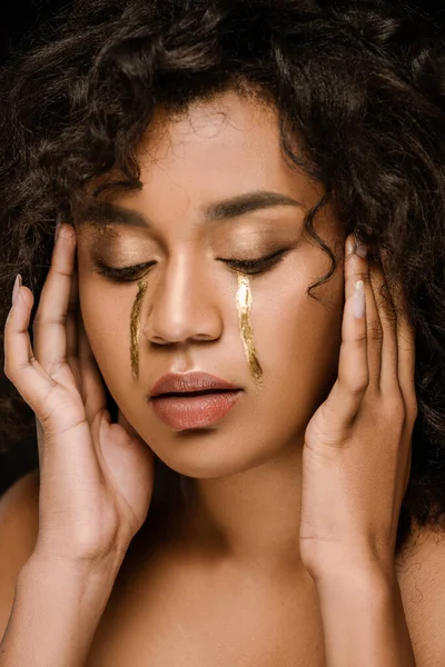 Femme afro-américaine bouclée avec des larmes dorées sur les joues et les yeux fermés — Photo de stock