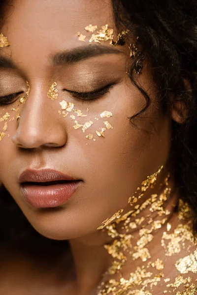 Close up of curly african american woman with golden paint on face and neck — Stock Photo