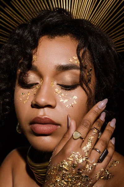 Close up of young african american woman with golden necklace and paint on cheeks — Stock Photo