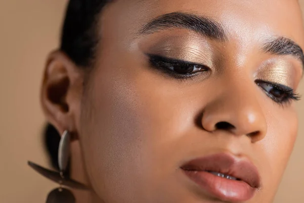 Close up de mulher americana africana com sombra dourada olho cintilante isolado no bege — Fotografia de Stock