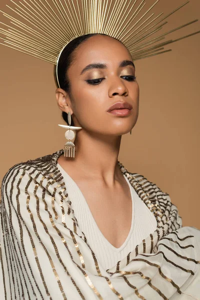 Ricca donna afroamericana in scialle lucido e corona d'oro posa isolata sul beige — Foto stock