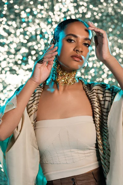 Piercing Africano americano mulher com folha de ouro no pescoço posando no fundo azul brilhante — Fotografia de Stock