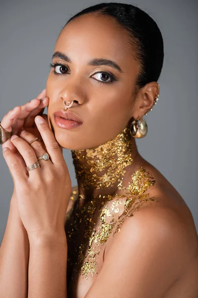 Portrait de modèle afro-américain élégant avec accessoires et feuille d'or sur la poitrine isolée sur gris — Photo de stock