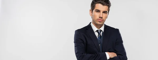 Homme d'affaires confiant en costume debout avec les bras croisés isolés sur gris, bannière — Photo de stock