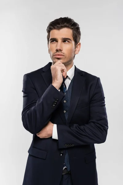 Pensive businessman in suit standing and looking away isolated on grey — Stock Photo