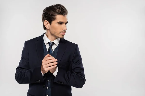 Гарний вигляд і молодий бізнесмен в костюмі, дивлячись ізольовано на сірий — стокове фото