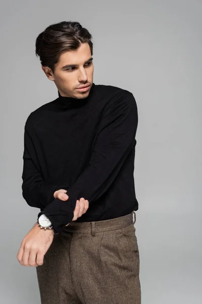 Good looking man in black turtleneck looking away while posing isolated on grey — Stock Photo