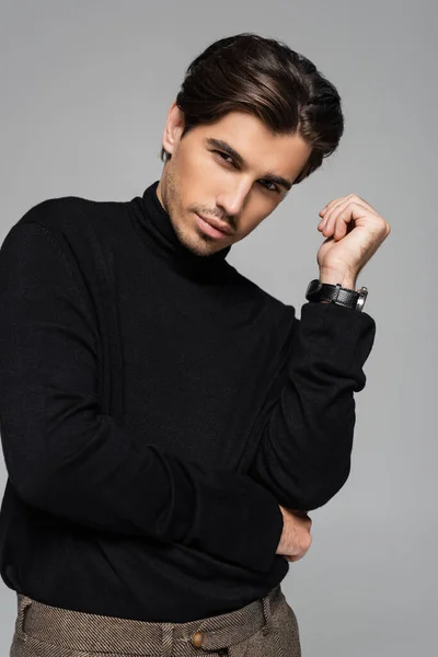Portrait of good looking man in black turtleneck posing isolated on grey — Stock Photo