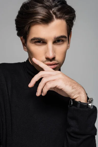 Portrait of good looking model in black turtleneck looking at camera while posing isolated on grey — Stock Photo