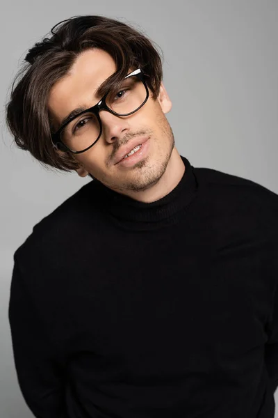 Portrait of brunette man in black turtleneck and eyeglasses posing isolated on grey — Stock Photo