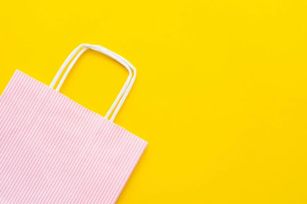 Draufsicht auf gestreifte Einkaufstasche auf gelbem Hintergrund — Stockfoto