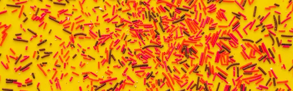 Top view of red and black sprinkles on yellow background, banner — Stock Photo
