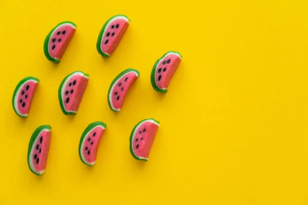 Vista superior de doces doces em forma de melancia no fundo amarelo — Fotografia de Stock