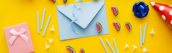 Draufsicht auf Süßigkeiten in der Nähe von Umschlag und festlichen Kerzen auf gelbem Hintergrund, Banner — Stockfoto