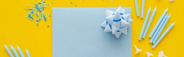 Top view of empty greeting card with candles and sprinkles on yellow background, banner — Stock Photo