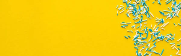 Vista superior de salpicaduras azules y blancas sobre fondo amarillo con espacio para copiar, banner - foto de stock