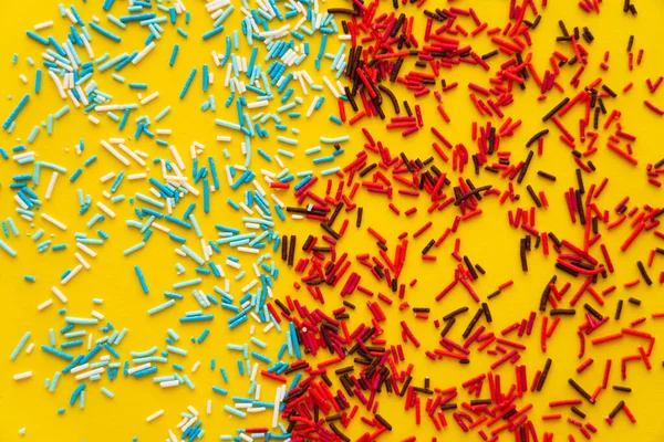Vista superior de polvilhas doces coloridas no fundo amarelo — Fotografia de Stock