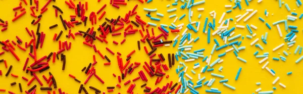 Top view of red and blue sprinkles on yellow background, banner — Stock Photo