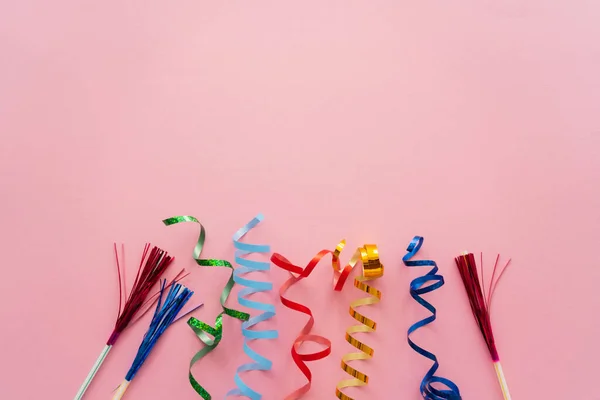 Top view of serpentine and drinking straws with tinsel on pink background — Stock Photo