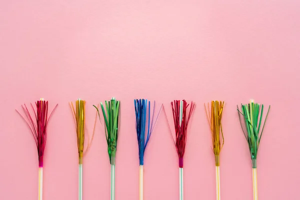 Top view of drinking straws with colorful tinsel on pink background with copy space — Stock Photo