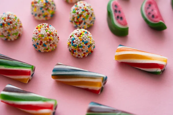 Close up view of different candies on pink background — Stock Photo