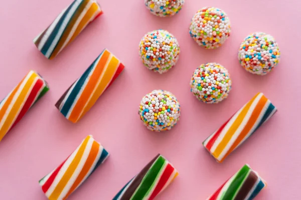 Acostado plano con dulces borrosas de colores sobre fondo rosa - foto de stock