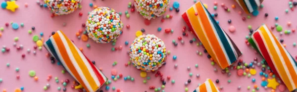 Top view of delicious sweets and sprinkles on pink background, banner — Stock Photo