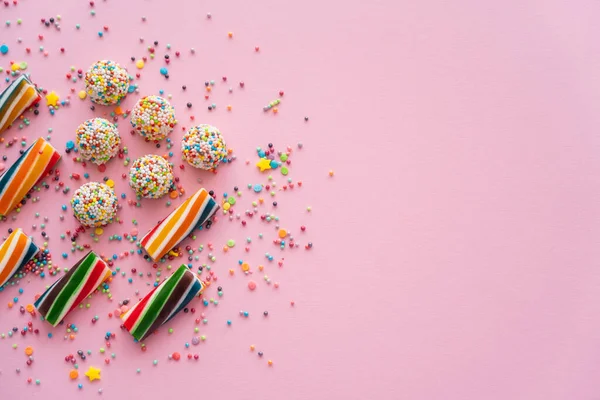 Draufsicht auf verschiedene bunte Süßigkeiten und Streusel auf rosa Hintergrund mit Kopierraum — Stockfoto