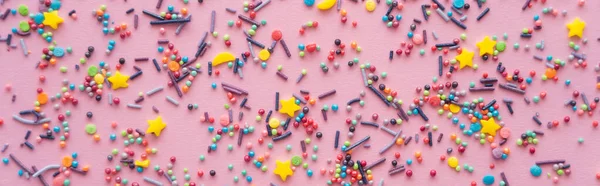 Top view of different sprinkles on pink background, banner — Stock Photo