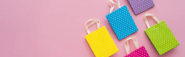 Top view of dotted shopping bags on pink background, banner — Stock Photo