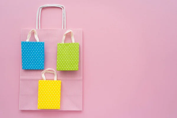 Draufsicht auf verschiedene Einkaufstaschen auf rosa Hintergrund — Stockfoto
