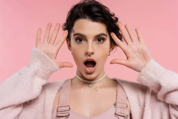 Schockierte brünette Frau mit offenem Mund schaut auf Kamera isoliert auf rosa — Stockfoto