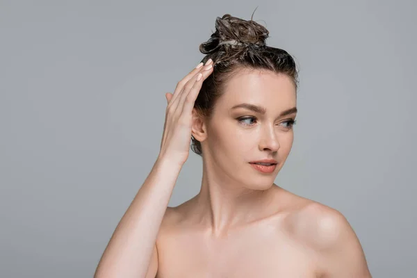 Junge Frau mit Schaum auf dem Kopf wäscht Haare isoliert auf grau — Stockfoto