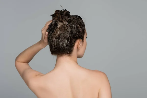 Vue arrière de la femme aux épaules nues lavant les cheveux isolés sur gris — Photo de stock