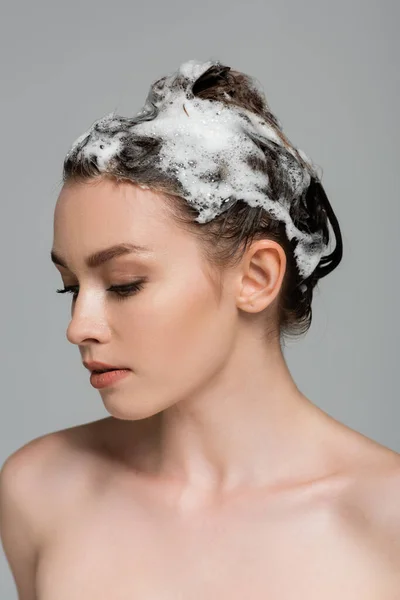 Jeune femme aux cheveux mousseux et mouillés isolé sur gris — Photo de stock