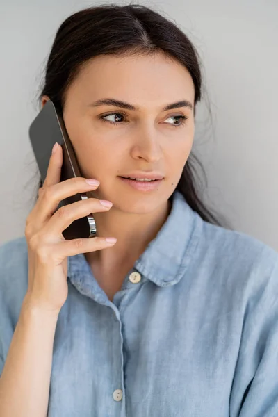 Portrait de femme souriante parlant sur smartphone isolé sur gris — Photo de stock