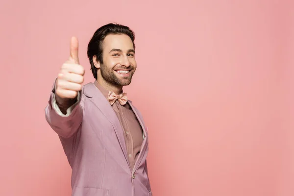 Cheerful host of event looking at camera and showing like gesture isolated on pink — Stock Photo