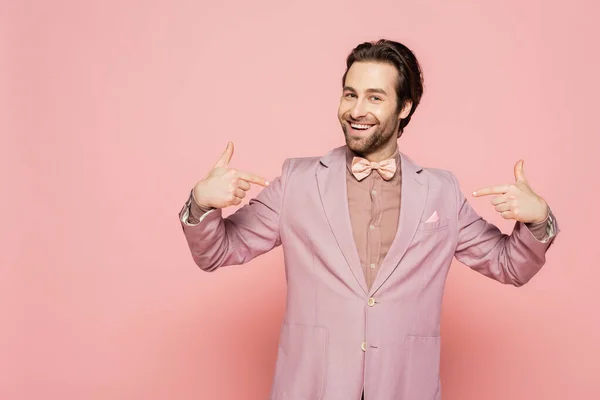 Positive Moderatorin in Jacke mit Fingern auf rosa Hintergrund — Stockfoto