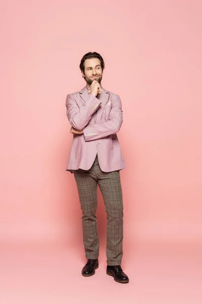 Full length of thoughtful host of event looking away on pink background — Stock Photo